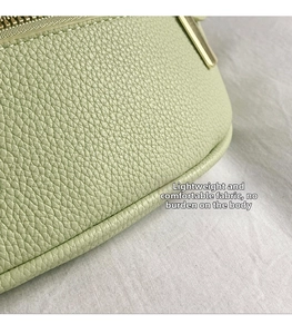 Détail du tissu vert clair à texture litchi avec fermeture éclair dorée de qualité