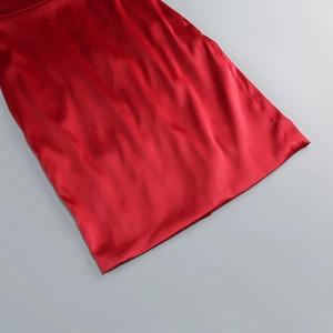 Détail du tissu en satin rouge avec fini brillant lisse et drapé élégant et doux