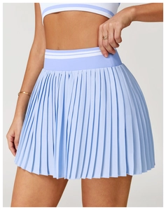 Detail of high-waisted pleated tennis skirt with white stripes and fine pleat texture