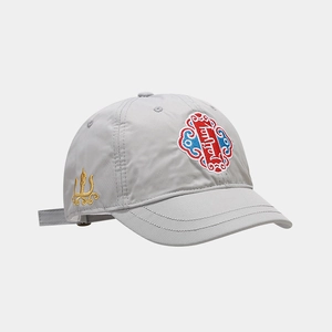 Dettaglio del cappello da baseball grigio con ricamo etnico e cuciture in seta dorata