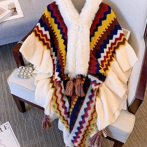 Ethnic style colorful wave pattern poncho with faux fur collar and tassels on a chair