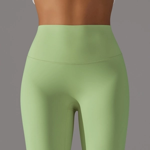Detail of high waist light green yoga pants featuring flatlock seams and matte fabric