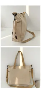 Detail of beige canvas tote bag showing side pocket and adjustable wide shoulder strap