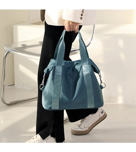 Detail of the navy blue nylon crossbody bag with reinforced handles and metal side hooks