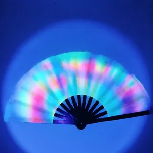 Macro shot of a light-up rainbow folding fan with black ribs and glowing fabric in dark