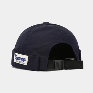 Detail of adjustable black strap and buckle on navy blue nylon brimless miki hat