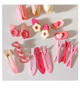 Flat lay of 13 pink and beige Y2K resin hair clips featuring flower and heart shapes
