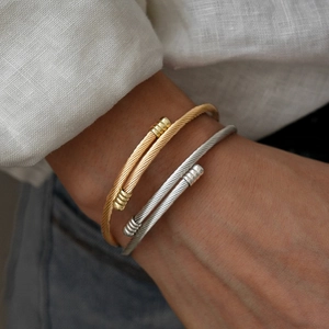 Classic gold and silver twisted cable cuff bracelets in minimalist geometric metal style