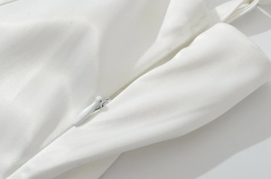 Détail de la fermeture éclair invisible sur la robe d'été blanche à taille ajustée