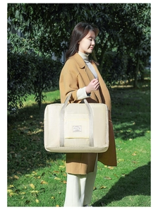 Detail of travel bag with reinforced handles and zipper pocket in outdoor setting