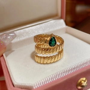 Close-up of gold butterfly ring with green teardrop gem in pink velvet gift box