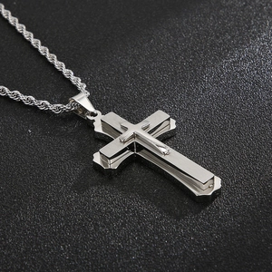 Macro detail of silver double-layered cross pendant with stainless steel rope chain