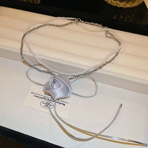 Detail of double-layer necklace with lavender silk rose and delicate pearl strand