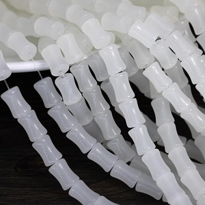 Macro shot of 6x12mm white translucent bamboo-shaped glass beads for jewelry making