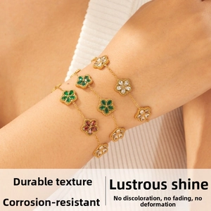 Dettaglio di tre braccialetti a catena floreale placcati in oro con petali di zircone