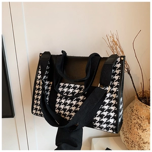 Detail of houndstooth fabric and black PU leather strap on this stylish tote bag