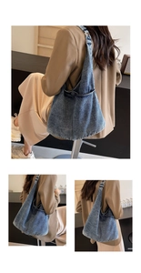 Detailed view of the blue denim hobo shoulder bag worn by a model in a modern cafe setting