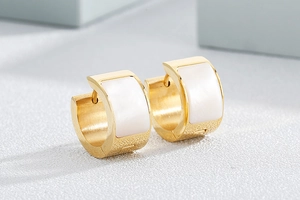Macro shot of gold-plated stainless steel earrings with white shell inlay detail