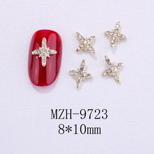 Dettaglio gioiello per unghie croce dorata con strass bianchi su unghia rossa, 8x10mm