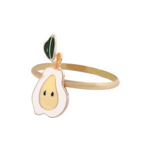 Detailed close-up of golden alloy napkin ring featuring a white and yellow pear enamel design