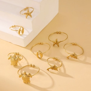 Detail view of gold-plated ocean-themed rings with turtle and starfish charms