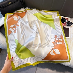 Foulard artistico in seta con motivi floreali verde oliva e arancio su pelliccia bianca