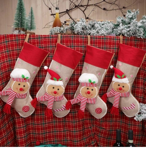 Detailed view of four burlap Christmas stockings with 3D gingerbread man and candy embroidery