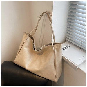 Minimalist beige soft leather tote bag resting in soft sunlight for daily commute