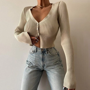 Detail of slim-fit knit cardigan showing deep V-neck and ribbed texture in beige