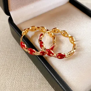 18k gold plated pig nose earrings with red enamel and pavé zircon in a jewelry box