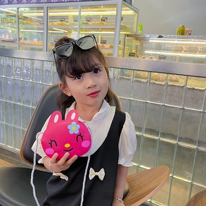 Cute pink cartoon bunny shoulder bag for girls with soft woven strap in a cafe