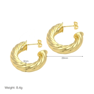 Detail view of 18k gold plated twisted C-shaped earrings with 29mm diameter and 9mm width