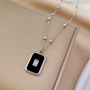 Detail of silver titanium steel necklace with black pendant and crystal on jewelry tray