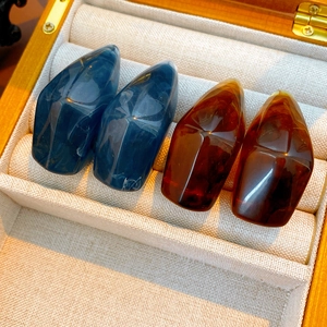 Close-up of vintage resin geometric earrings with marble texture in a wooden jewelry box
