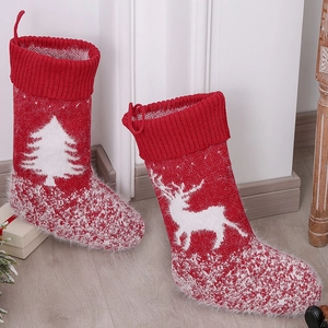 Knitted wool Christmas stockings with reindeer and tree patterns on wooden floor