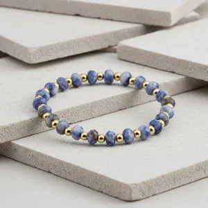 Detailed close-up of 4mm faceted blue stone beads and gold metal spacers on jewelry