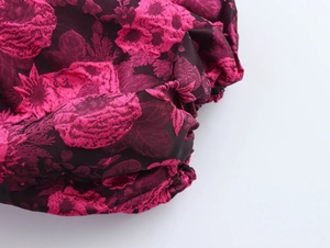 Close-up of pink and black floral jacquard fabric on a puff sleeve dress