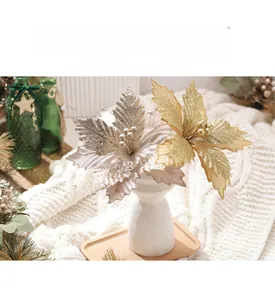 Close-up of golden and silver velvet poinsettias with glitter and beads in a vase