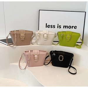 Multiple woven bucket bags in five colors with central gold oval metal buckle detail