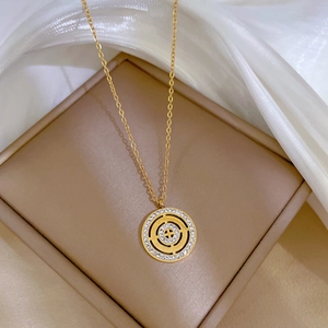 Macro shot of gold Roman disc pendant with inner maze pattern and sparkling zircon stones