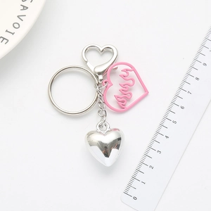 Cool heart keychain featuring silver solid heart and pink flame patterned charms