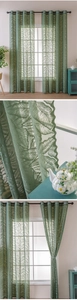 Detail of green lace sheer curtain with leaf pattern textures and grommet top header