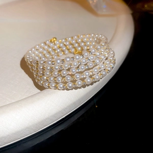 Gros plan d'un bracelet de perles multicouche luxueux avec des séparateurs en strass dorés