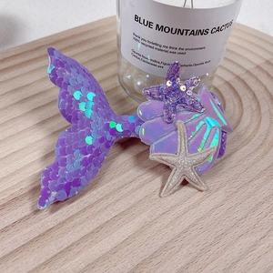 Detail of purple sequin mermaid tail hair clip with starfish and shell ornaments