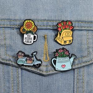 Lot de quatre pin's en émail colorés avec tournesols et tulipes sur une veste en denim