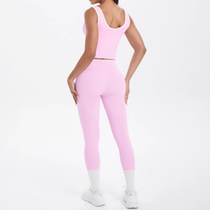 Rear view of pink yoga set with white trim details on cross back sports bra and leggings