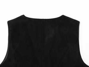 Gros plan du gilet noir en suédine montrant la texture brodée et les détails du tissu doux