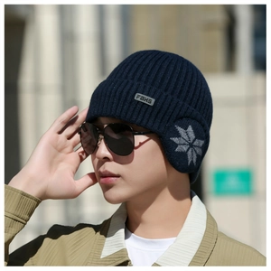 Close-up of men's navy blue earflap beanie with snowflake pattern and FBKS leather label