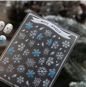 Macro detail of winter snowflake nail stickers in icy blue and silver glitter finish