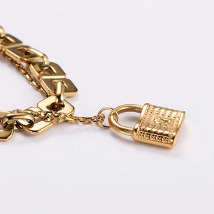 Gold layered curb chain bracelet featuring a vintage embossed padlock charm pendant